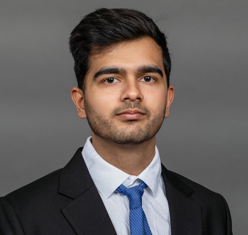 Portrait of Abheek Bajaj in a dark suit and blue tie